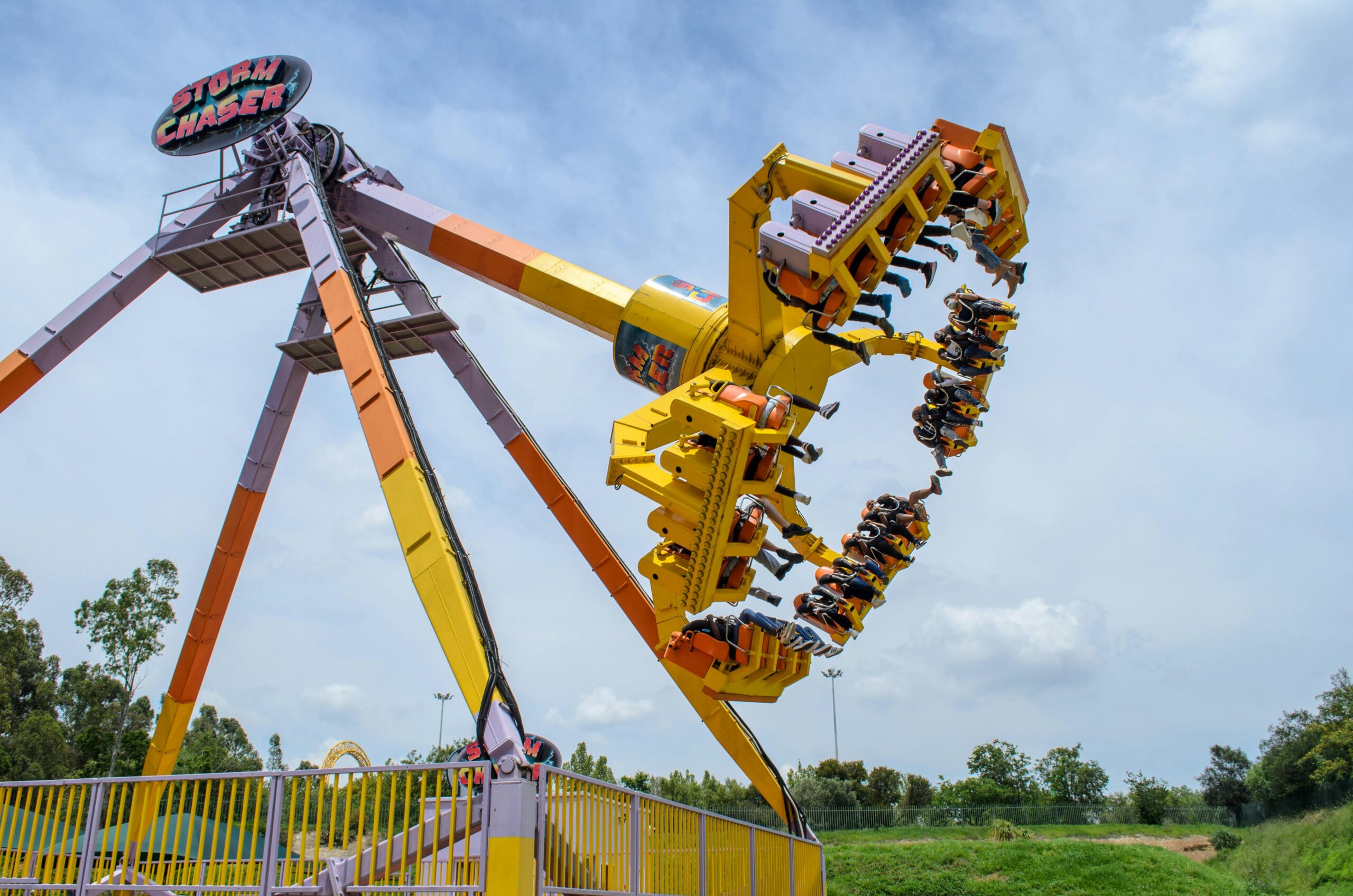 High-energy thrill ride at carnival featuring the Storm Chaser with people having fun.