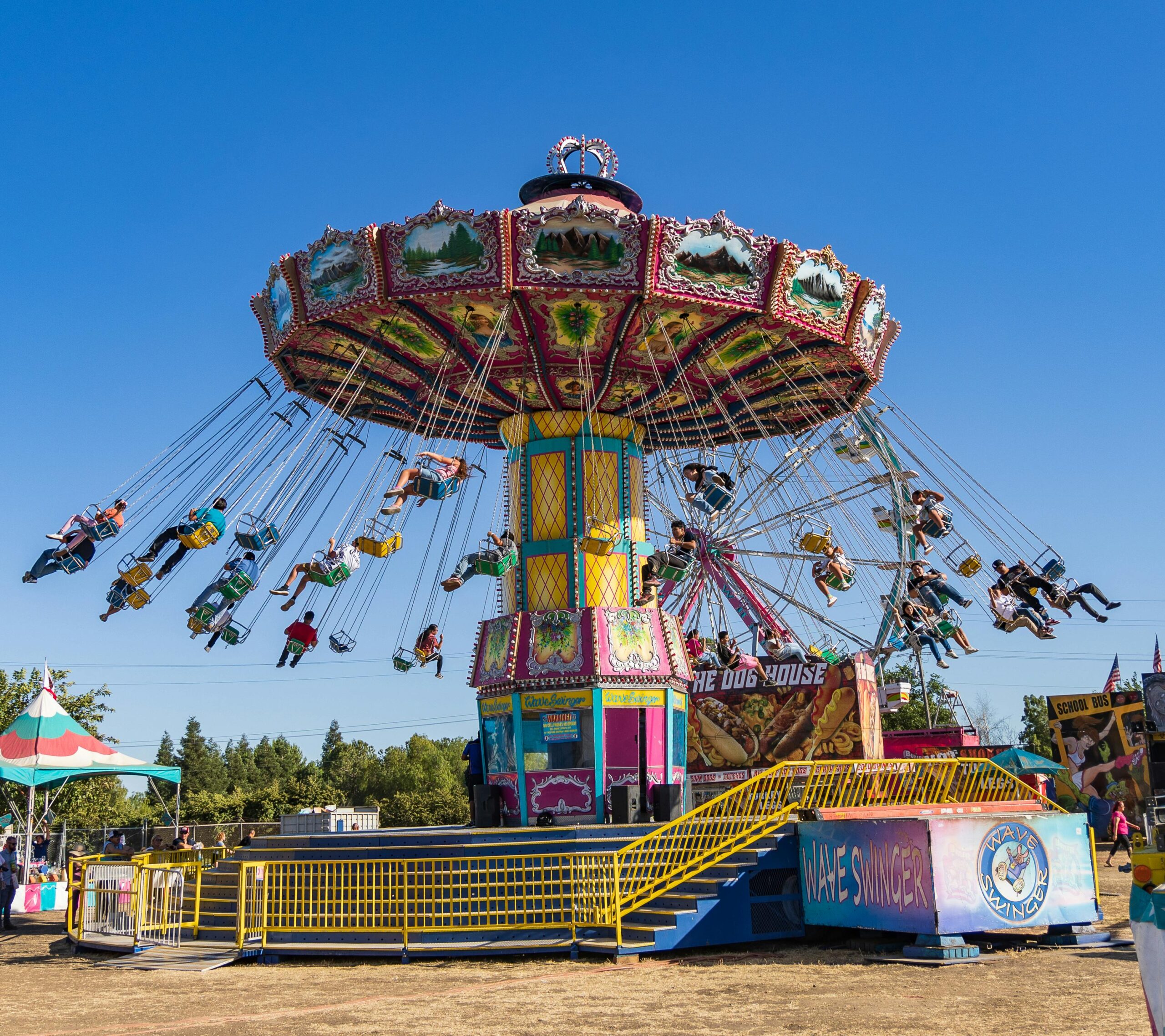 Vibrant carousel ride at Merced County Fair in California on a sunny day, showcasing joyful amusement park fun.